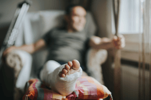 man sitting in chair with leg in cast